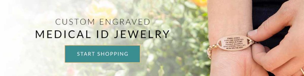 Woman wearing custom engraved rose gold medical ID tag standing near field of flowers.