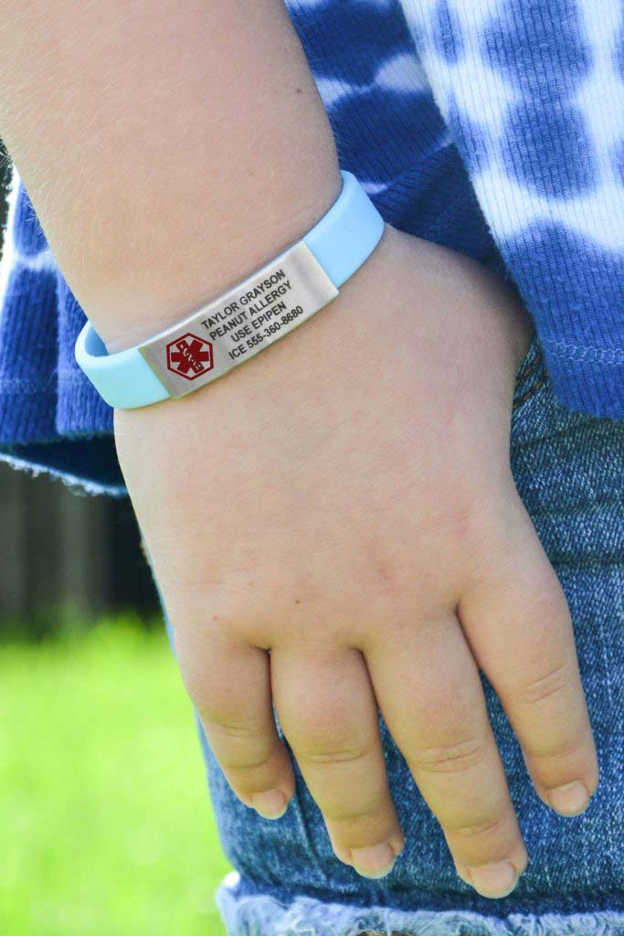 Child wearing custom engraved medical alert band, shown on wrist. 